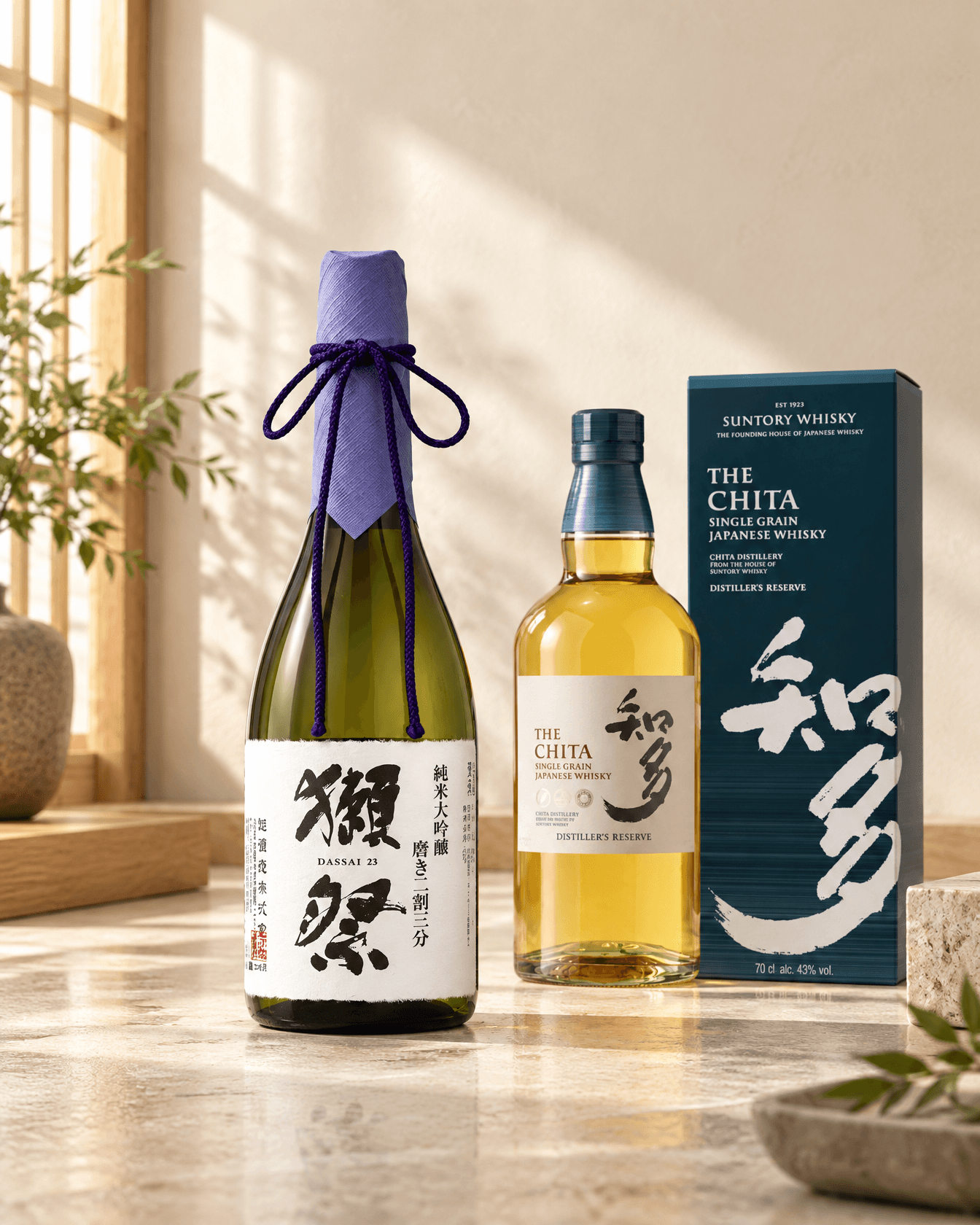Dassai 23 Junmai Daiginjo beside The Chita single grain Japanese whisky and its gift box on a pale stone counter